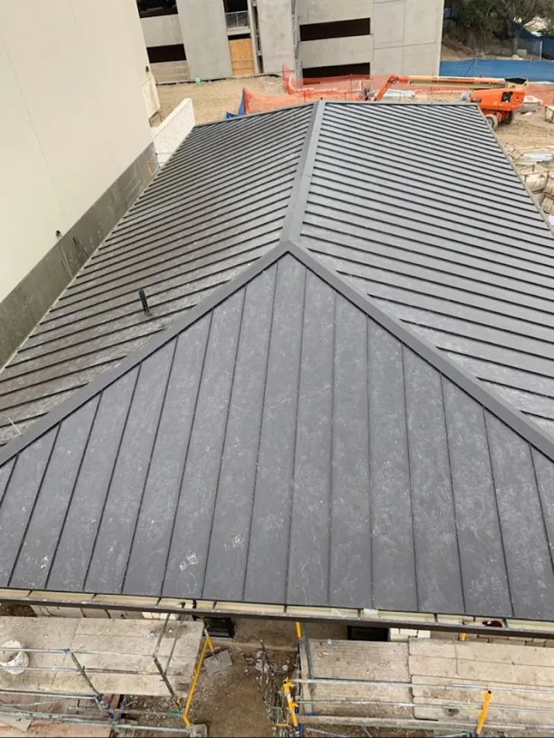 Commercial metal roof construction with crane equipment in Elyria